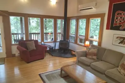 a living room with a couch and a wood stove at The Cabin at Moon Dance in Garden Bay