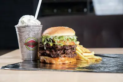 a hamburger and french fries and a drink on a table at River Cree Resort & Casino in Edmonton