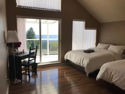a bedroom with two beds and a desk with a window at Emperial Suites in North Vancouver