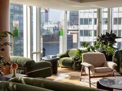 a room with chairs and tables and large windows at Fairmont Pacific Rim in Vancouver