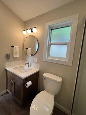 a bathroom with a toilet and a sink and a window at The Lodge on Harrison Lake in Harrison Hot Springs