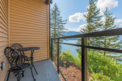 a balcony with a table and chairs and a view at The Lodge on Harrison Lake in Harrison Hot Springs