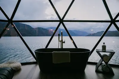a bath tub with a cross and a candle in front of the water at The Lodge on Harrison Lake in Harrison Hot Springs