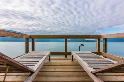 a wooden dock with a view of the water at The Lodge on Harrison Lake in Harrison Hot Springs