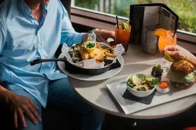 a woman sitting at a table with a plate of food at Hotel Eldorado at Eldorado Resort in Kelowna