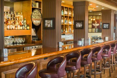 a bar with a row of brown leather chairs at Hotel Eldorado at Eldorado Resort in Kelowna