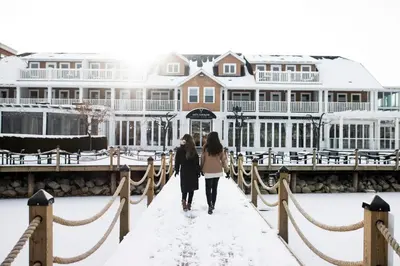 two women walking across a bridge in the snow at Hotel Eldorado at Eldorado Resort in Kelowna