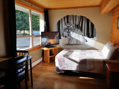 a bedroom with a wolf picture on the wall at Overlook Inn & Cabins in Clearwater
