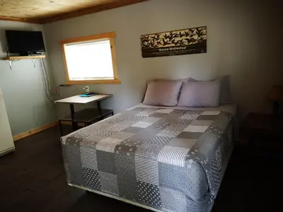 a bedroom with a bed and a window and a table at Overlook Inn & Cabins in Clearwater