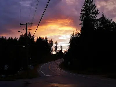 an empty road with a sunset in the background at Overlook Inn & Cabins in Clearwater