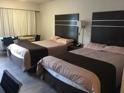 a hotel room with two beds and a table at Bear Country Inn in Terrace