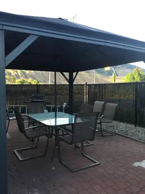 a table and chairs under an umbrella on a patio at The Ranchland Inn Kamloops in Kamloops