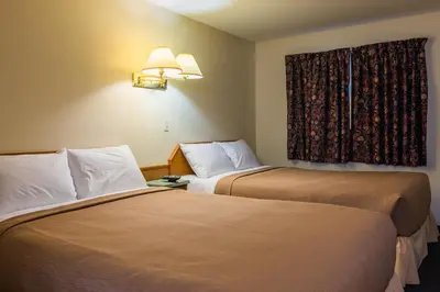 a hotel room with two beds and a window at The Ranchland Inn Kamloops in Kamloops