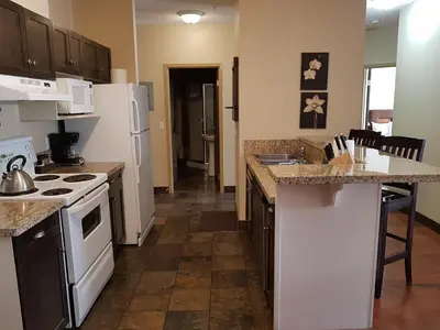 a kitchen with a white stove and a counter top at Sunset Resorts Canmore and Spa in Canmore