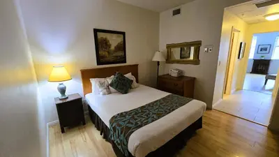 a hotel room with a bed and a hallway at Sunset Mountain Inn in Canmore