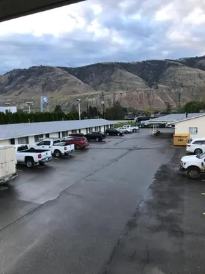 a parking lot with cars parked in front of a building at Trans Canada Motel in Kamloops