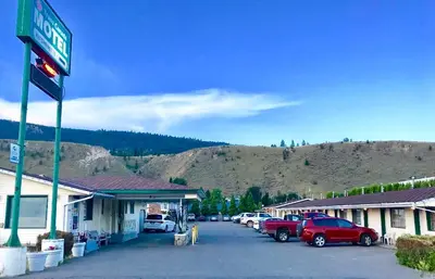 a gas station with cars parked in a parking lot at Trans Canada Motel in Kamloops
