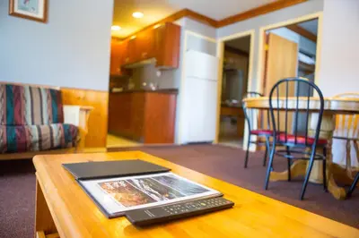 a table with a remote control on top of a table at Glacier House Hotel & Resort in Revelstoke