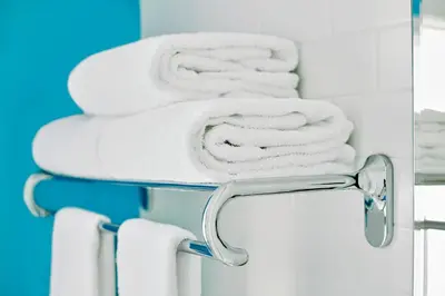 a towel rack with white towels on it at The Burrard in Vancouver