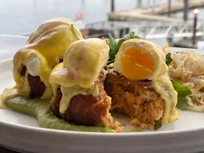 a plate of food with fried eggs and lettuce at Coast Victoria Hotel & Marina by APA in Victoria