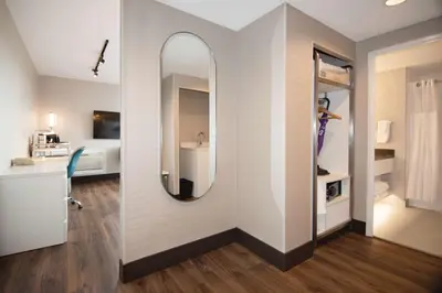 a person taking a picture of a bathroom with a mirror at Coast Victoria Hotel & Marina by APA in Victoria
