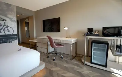 a bedroom with a bed and a desk and a chair at Coast Victoria Hotel & Marina by APA in Victoria