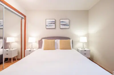 a bedroom with a large white bed with two lamps at Lagoons by Outpost Whistler in Whistler