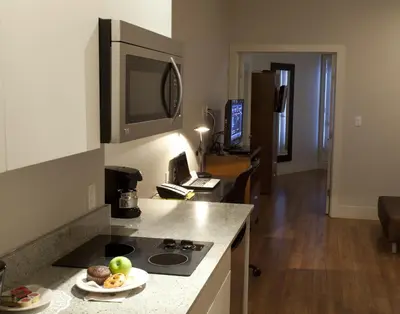 a kitchen with a stove and a plate of food on a counter at Baymont by Wyndham Fort McMurray in Fort McMurray