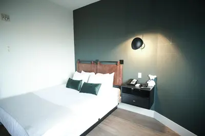 a bedroom with a white bed and a black wall at Baymont by Wyndham Fort McMurray in Fort McMurray
