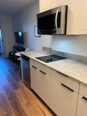 a kitchen with a stove and a microwave at Baymont by Wyndham Fort McMurray in Fort McMurray