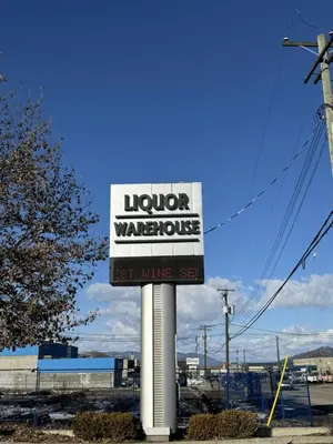 a sign for a liquor warehouse on a street at Divya Sutra Plaza and Conference Centre, Vernon, BC in Vernon