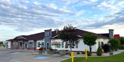 a building in a parking lot next to a street at Western Budget Motel Leduc #3 in Leduc