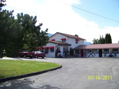 a red truck parked in front of a building at Bavarian Orchard Motel in Creston