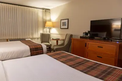 a hotel room with two beds and a flat screen tv at Whistler's Inn in Jasper
