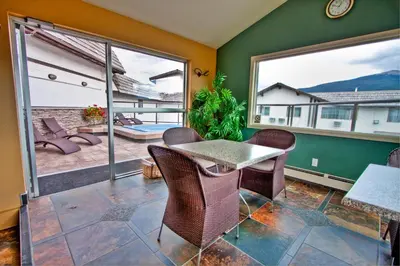 a room with a table and chairs and a patio at Whistler's Inn in Jasper