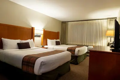 a hotel room with two beds and a television at Whistler's Inn in Jasper