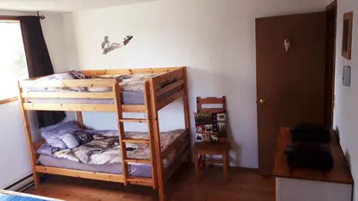 a bedroom with two bunk beds in a room at Wettstone Guest Ranch in Bridge Lake