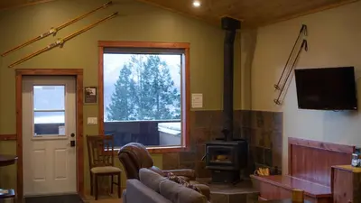 a living room with a couch and a wood stove at Cedar House Restaurant & Chalets in Golden
