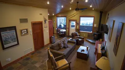 a living room with a couch and a tv at Cedar House Restaurant & Chalets in Golden