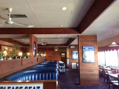 a restaurant with a row of blue leather seats at Moby Dick Inn in Prince Rupert