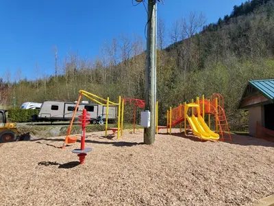 a playground with a yellow and orange play equipment at Camperland RV Resort & Cabins in Rosedale