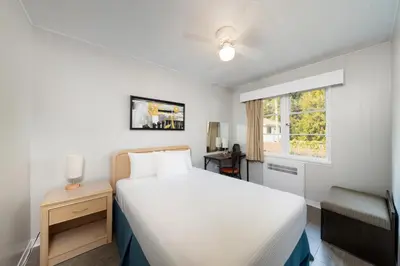 a bedroom with a white bed and a window at 2400 Motel in Vancouver