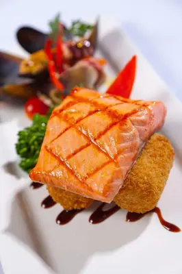a plate of food with salmon and vegetables on it at Granville Island Hotel in Vancouver