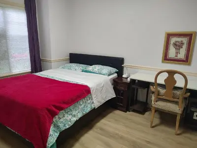 a bedroom with a bed and a desk and a chair at Go House in Richmond