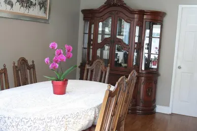 a table with a vase with purple flowers on it at Semi Centre House in White Rock