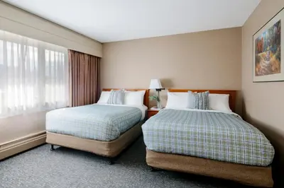 a hotel room with two beds and a window at Lobstick Lodge in Jasper