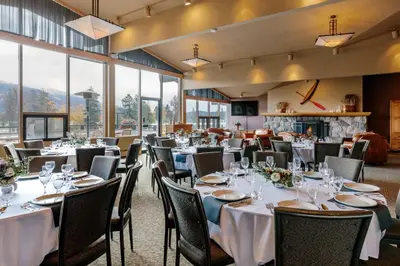a dining room with tables and chairs and a fireplace at Lobstick Lodge in Jasper