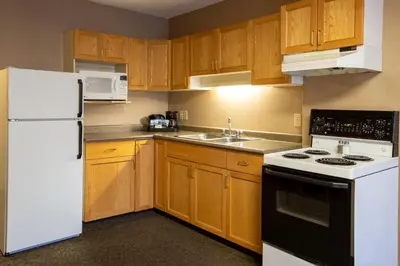 a kitchen with wooden cabinets and a white refrigerator at Lobstick Lodge in Jasper