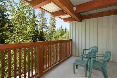 a porch with two chairs and a wooden railing at Horstman House by Whistler Premier in Whistler