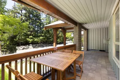 a porch with a wooden table and chairs at Horstman House by Whistler Premier in Whistler